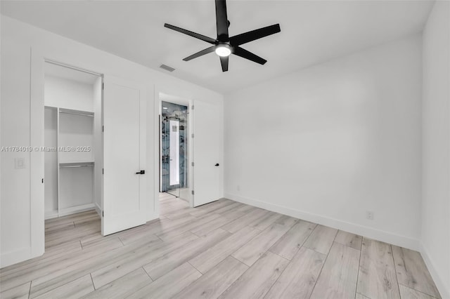 2138 SW 3rd Ave, Cape Coral, FL 33991 - unfurnished bedroom featuring a walk in closet, wood finished floors, a closet, and a ceiling fan
