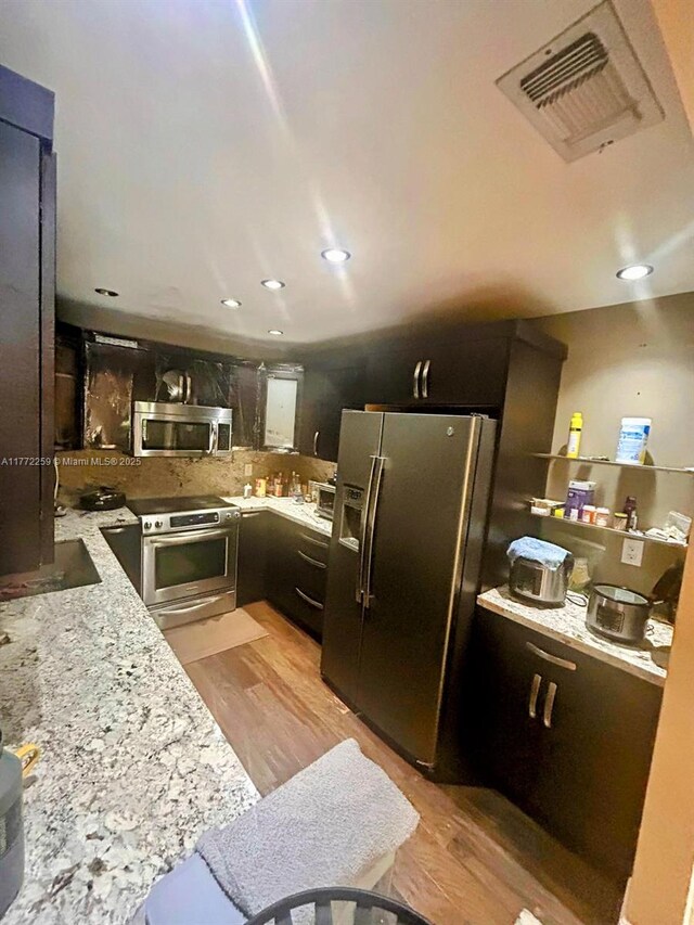 470 N Laurel Dr Unit 6A, Margate, FL 33063 - kitchen with appliances with stainless steel finishes, light wood-style flooring, decorative backsplash, light stone counters, and recessed lighting