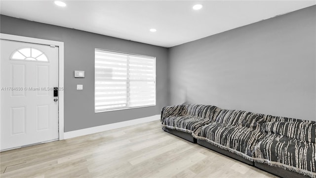 living area with baseboards, recessed lighting, and wood finished floors