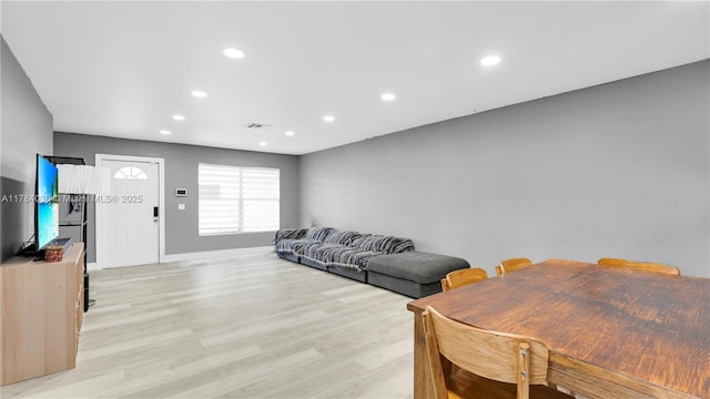 living area with light wood finished floors, recessed lighting, visible vents, and baseboards