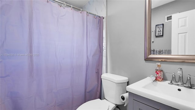 bathroom featuring a shower with shower curtain, toilet, and vanity