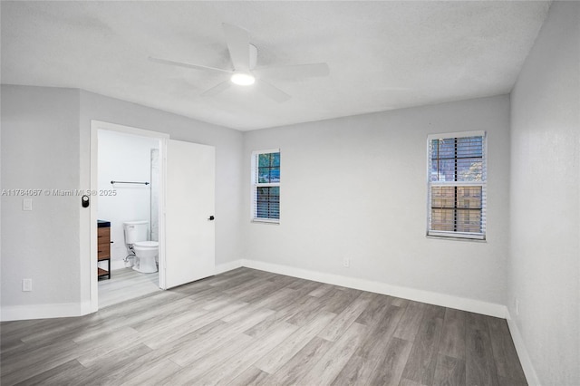 unfurnished room with a healthy amount of sunlight, baseboards, a ceiling fan, and wood finished floors
