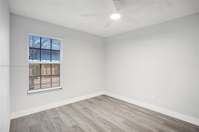 spare room featuring ceiling fan, baseboards, and wood finished floors