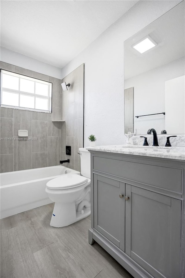 full bath featuring washtub / shower combination, vanity, toilet, and wood finished floors