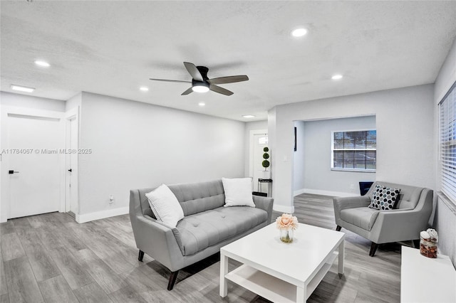 living area with recessed lighting, a ceiling fan, and wood finished floors