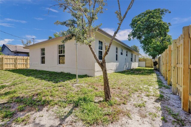 exterior space with a yard, stucco siding, and a fenced backyard
