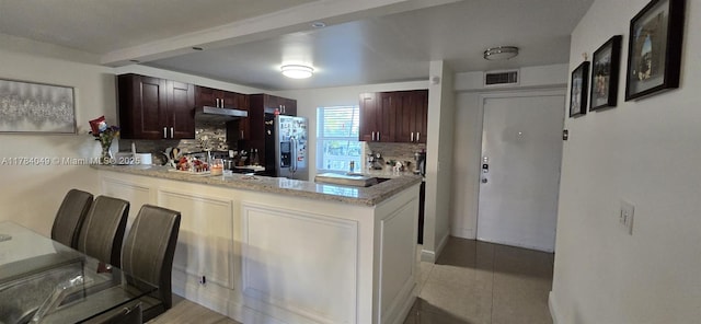 431 SE 3rd St Unit 205, Dania Beach, FL 33004 - kitchen featuring a peninsula, visible vents, backsplash, and stainless steel fridge