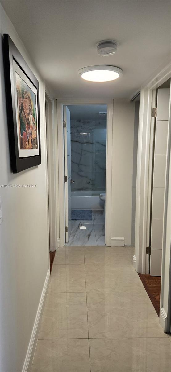 431 SE 3rd St Unit 205, Dania Beach, FL 33004 - corridor featuring marble look tiles and baseboards