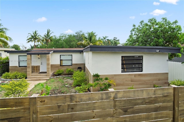 view of front of property featuring fence and stucco siding
