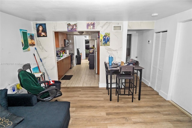dining room with light wood-style floors and visible vents
