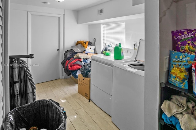 washroom featuring light wood-style floors, separate washer and dryer, laundry area, and visible vents