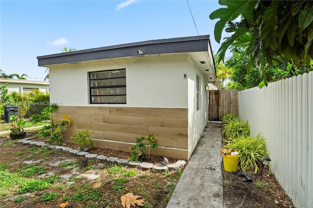 view of side of property featuring a fenced backyard and stucco siding