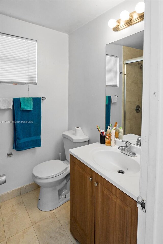 full bath featuring baseboards, toilet, a shower stall, vanity, and tile patterned flooring
