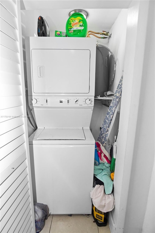 washroom featuring stacked washer / dryer and laundry area