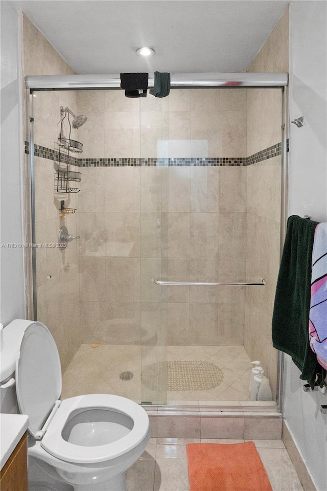 bathroom with a shower stall, tile patterned floors, vanity, and toilet