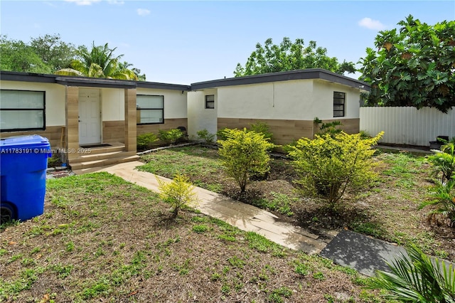 view of front of property with fence and stucco siding