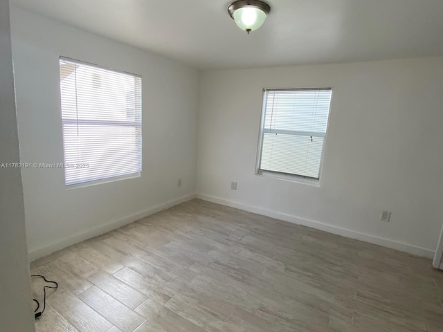 unfurnished room with wood finished floors and baseboards