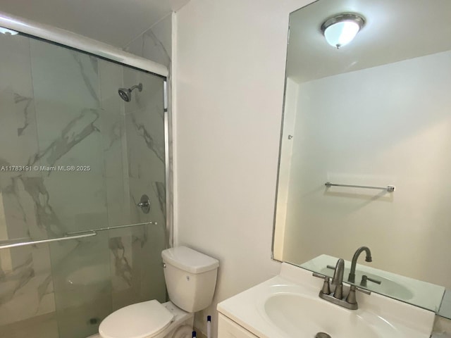 bathroom featuring a marble finish shower, toilet, and vanity