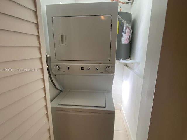 laundry area featuring stacked washer / dryer, laundry area, and tile patterned flooring