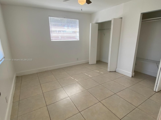 unfurnished bedroom with light tile patterned floors, baseboards, and a ceiling fan