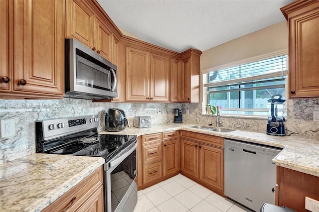 7324 NW 1st Pl, Plantation, FL 33317 - kitchen featuring appliances with stainless steel finishes, light tile patterned floors, brown cabinets, decorative backsplash, and a sink