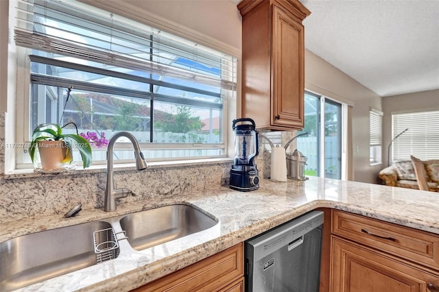 7324 NW 1st Pl, Plantation, FL 33317 - kitchen featuring brown cabinets, dishwasher, a sink, and light stone countertops