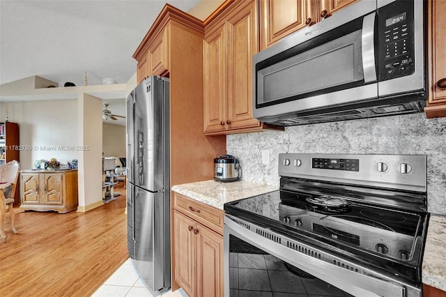 7324 NW 1st Pl, Plantation, FL 33317 - kitchen featuring tasteful backsplash, light wood-style flooring, appliances with stainless steel finishes, and light stone counters