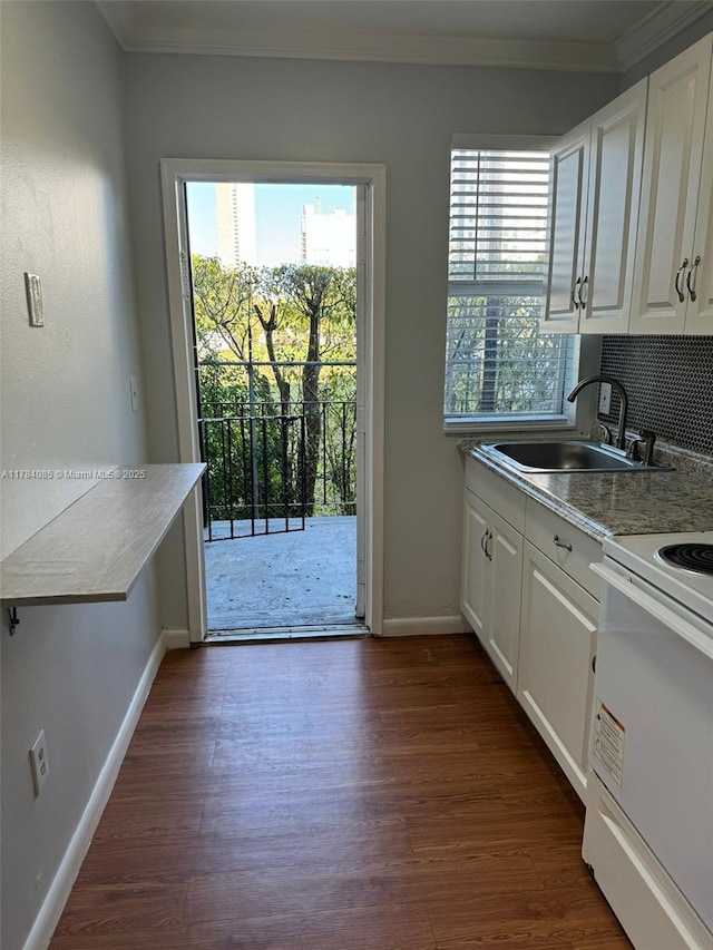 kitchen featuring ornamental molding, white cabinets, a sink, baseboards, and electric range oven