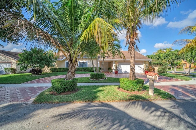 4991 NW 72nd Ter, Lauderhill, FL 33319 - view of property hidden behind natural elements with a front lawn, stucco siding, an attached garage, and decorative driveway