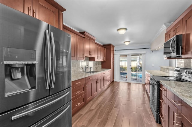 4991 NW 72nd Ter, Lauderhill, FL 33319 - kitchen featuring a sink, appliances with stainless steel finishes, brown cabinets, and ornamental molding