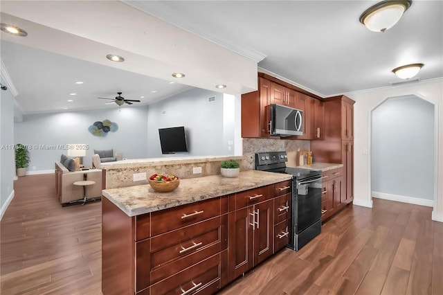4991 NW 72nd Ter, Lauderhill, FL 33319 - kitchen with dark wood-style flooring, stainless steel microwave, backsplash, and electric range