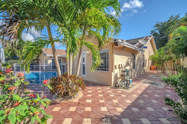 4991 NW 72nd Ter, Lauderhill, FL 33319 - view of home's exterior with a patio, stucco siding, a fenced in pool, and fence