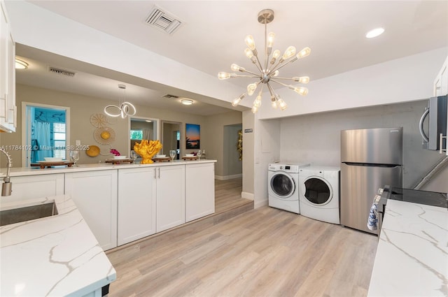 3313 SE 3rd St, Pompano Beach, FL 33062 - laundry room featuring washer and dryer, a chandelier, light wood-style flooring, baseboards, and recessed lighting