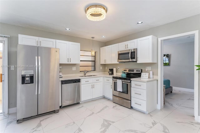 3313 SE 3rd St, Pompano Beach, FL 33062 - kitchen featuring stainless steel appliances, a sink, white cabinets, light countertops, and light marble finish flooring