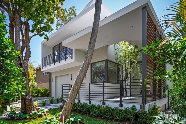 510 NE 52nd St, Miami, FL 33137 - view of side of property featuring stucco siding, an attached garage, and a balcony