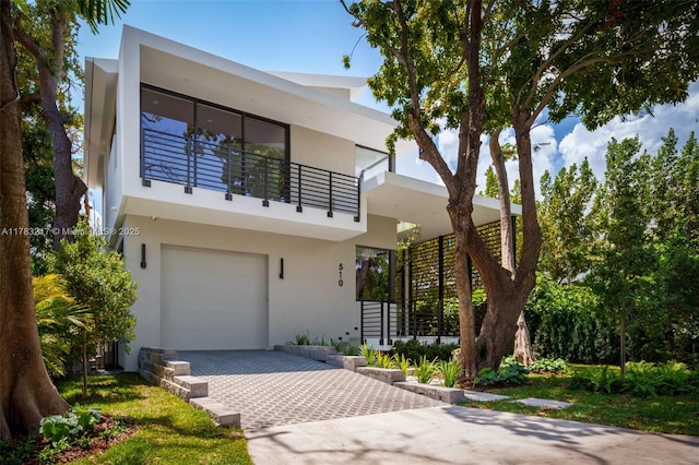 510 NE 52nd St, Miami, FL 33137 - contemporary house with a balcony, stucco siding, a garage, and decorative driveway