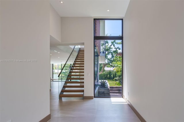 510 NE 52nd St, Miami, FL 33137 - entryway featuring stairs, baseboards, a wall of windows, tile patterned floors, and recessed lighting