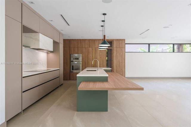 510 NE 52nd St, Miami, FL 33137 - kitchen featuring a sink, modern cabinets, stainless steel double oven, light countertops, and a center island with sink