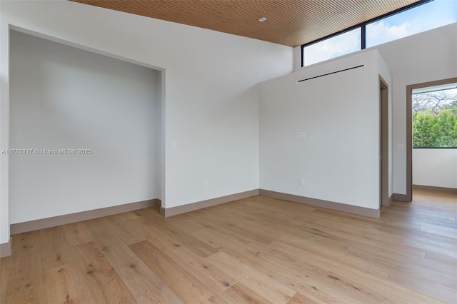 510 NE 52nd St, Miami, FL 33137 - empty room with a high ceiling, light wood-style floors, and baseboards