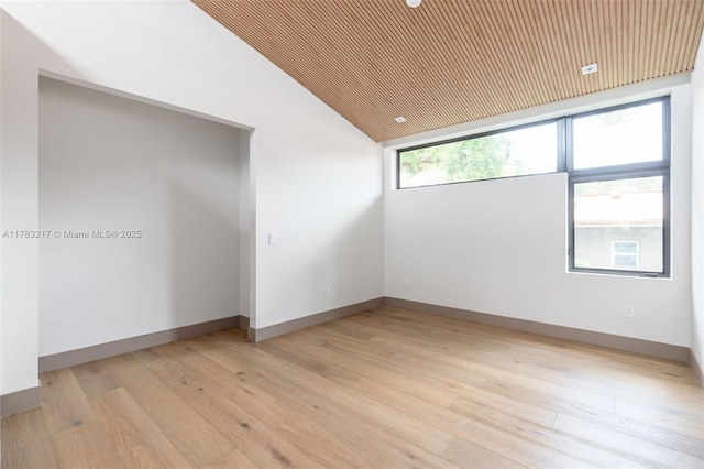 510 NE 52nd St, Miami, FL 33137 - empty room featuring light wood-style flooring, vaulted ceiling, and baseboards