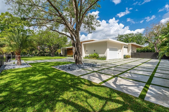view of yard with a garage and driveway