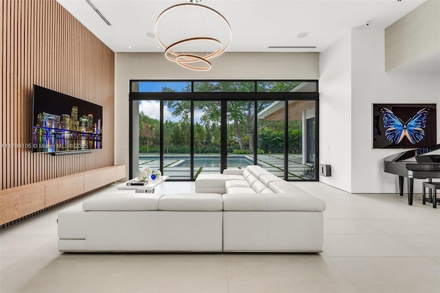 living area with a towering ceiling, tile patterned flooring, and a chandelier