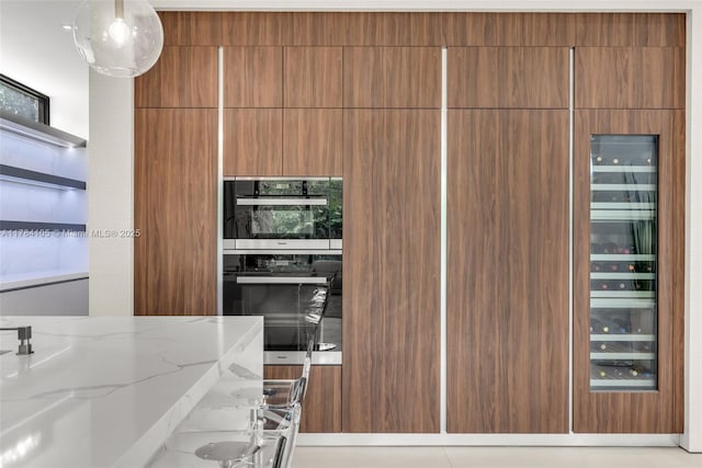 kitchen featuring light stone counters, modern cabinets, brown cabinetry, and wine cooler