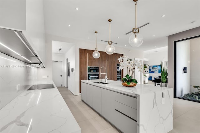 kitchen featuring modern cabinets, black electric cooktop, a sink, hanging light fixtures, and light tile patterned floors