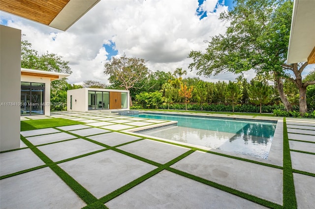 swimming pool featuring a patio and an outdoor structure