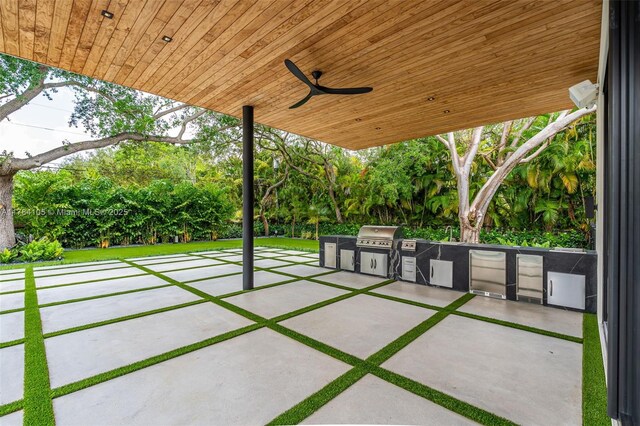 view of patio with an outdoor kitchen, area for grilling, and ceiling fan