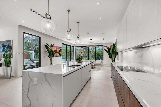 kitchen with a sink, modern cabinets, black electric stovetop, white cabinets, and open floor plan