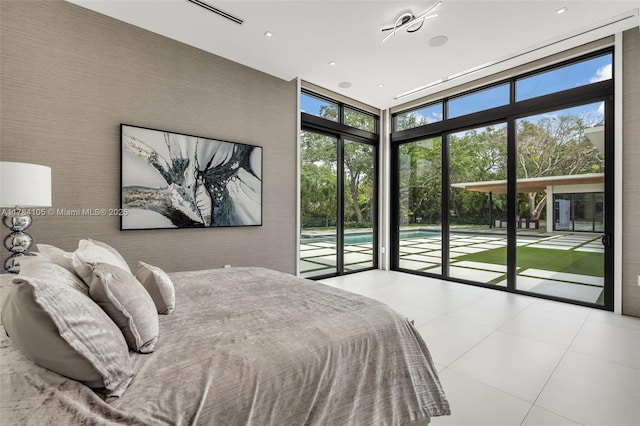 bedroom with access to exterior, a wall of windows, and tile patterned floors