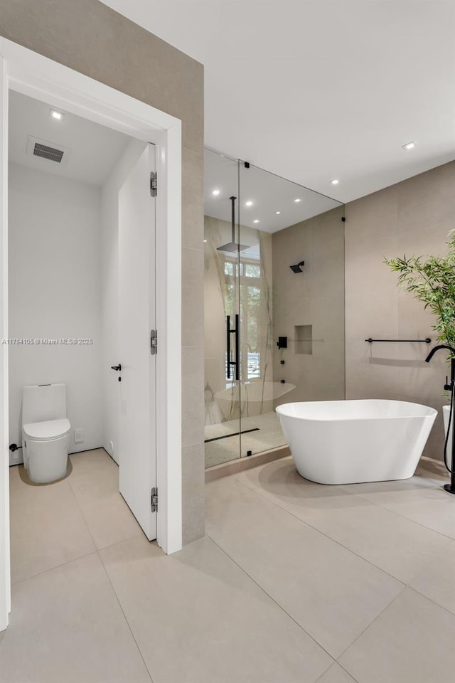 full bathroom featuring a stall shower, a soaking tub, tile patterned floors, toilet, and recessed lighting