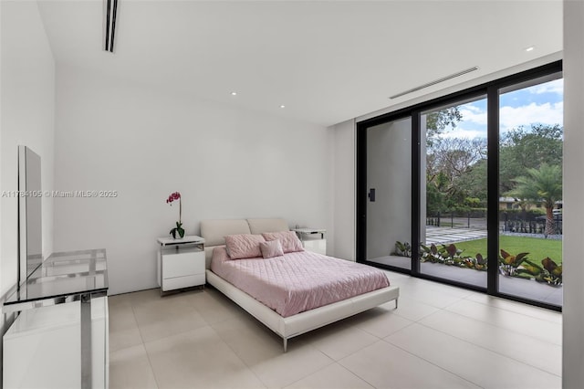 bedroom featuring access to outside, light tile patterned floors, and floor to ceiling windows
